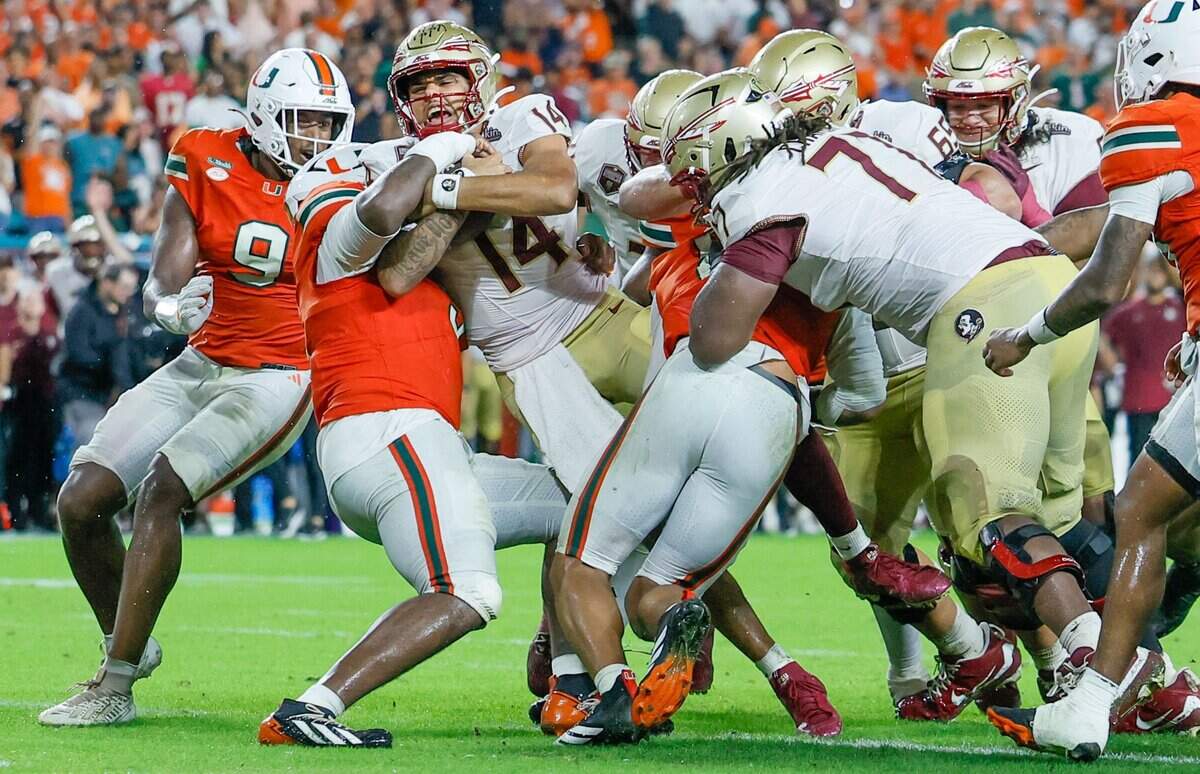 Florida State Seminoles quarterback Ashton Daniels (14) pushes his way into the end zone to score in the second quarter as Miami Hurricanes defensive lineman Justin Scott (5) attempts to make the stop at Hard Rock Stdium in Miami Gardens, Florida, on Saturday, October 17, 2026.