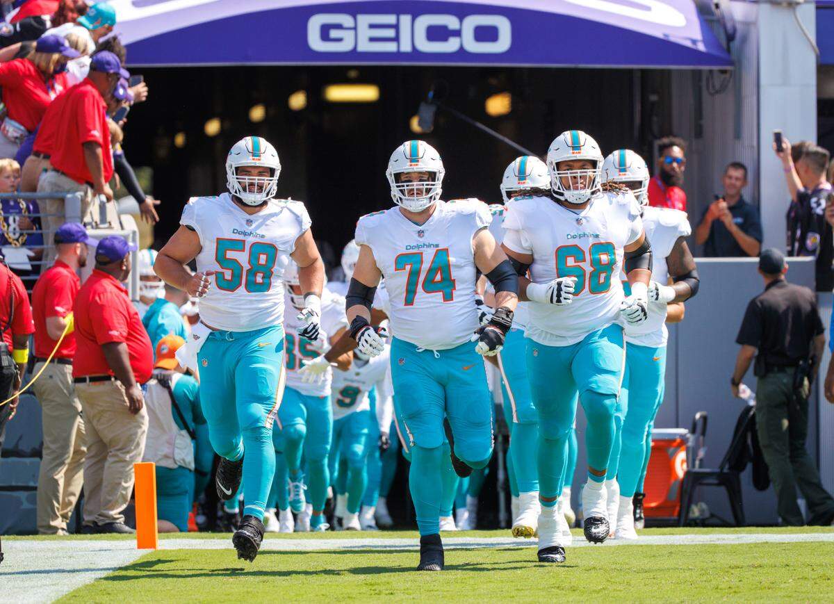 Miami Dolphins players Connor Williams (58) Liam Eichenberg (74) and Robert Hunt (68) take the field before the start of an NFL football game against the Baltimore Ravens at M&T Bank Stadium on Sunday, September 18, 2022 in Baltimore, MD.
