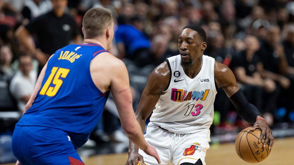 Miami Heat center Bam Adebayo (13) dribbles while Denver Nuggets center Nikola Jokić (15) defends during the third quarter of an NBA game at the Miami-Dade Arena on Monday, Feb. 13, 2023, in downtown Miami, Fla.