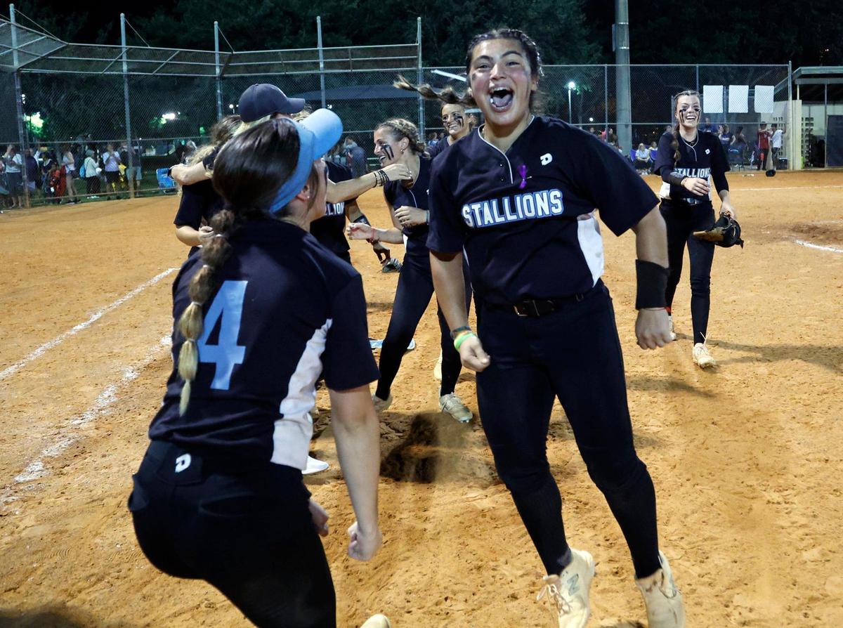 Somerset Academy Silver Palms Arlene Sordo (5) leaps as she celebrates the win against the Coral Springs Charter varsity softball team in the regional softball championship at Betti Stradling Park in Coral Springs on Friday.