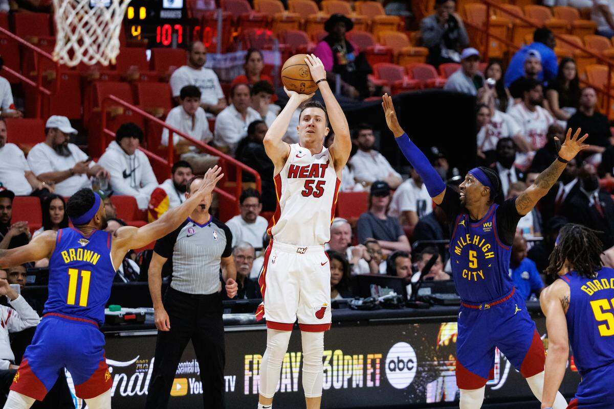 Miami Heat forward Duncan Robinson (55) take a shot against the defense of Denver Nuggets forward Bruce Brown (11) and Nuggets guard Kentavious Caldwell-Pope (5) during the second half of Game 3 of the NBA Finals at the Kaseya Center on Wednesday, June 7, 2023, in Miami, Florida.
