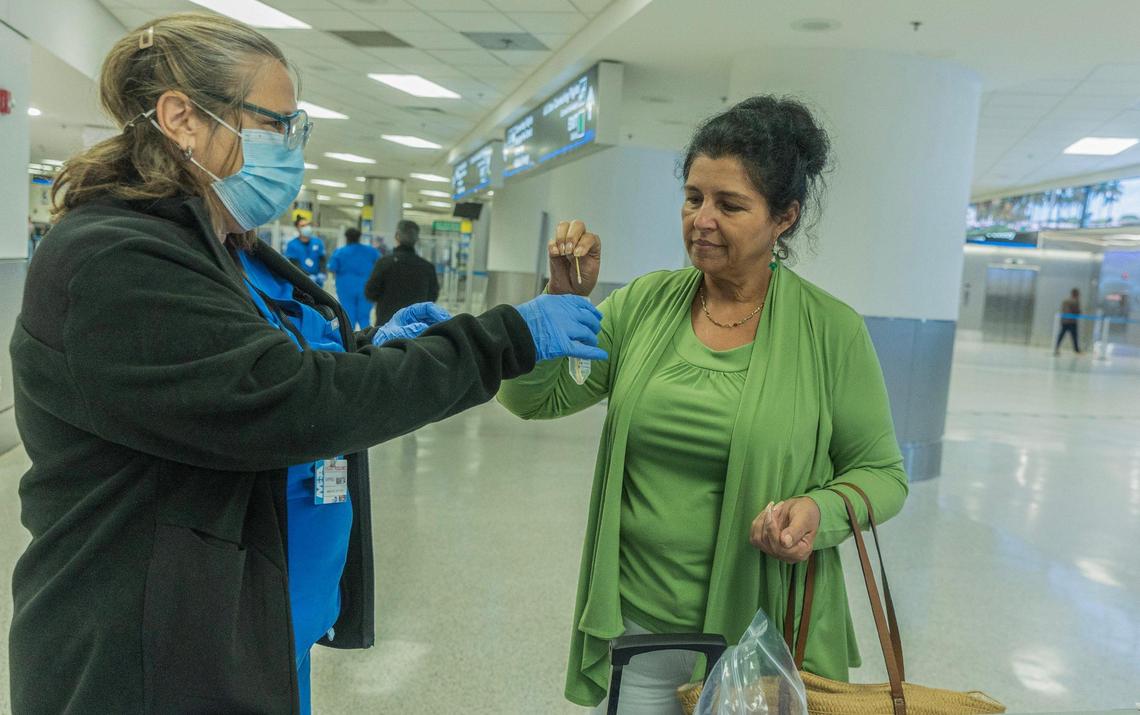 Bio surveillance specialist Talia Estevez assists traveler Ana Lidia Lujan arriving from Cuba as she swabs her nose for a voluntary test as some travelers flying into Miami from other countries are being asked to do a nose swab to test for COVID variants and other contagious viruses as part of a nationwide effort to track new and emerging infectious diseases, on Thursday, March 14, 2024.