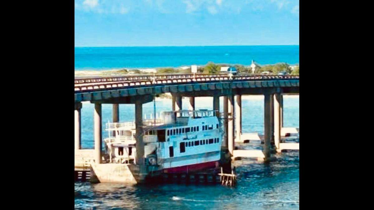A 75-foot boat destined to be sunk for an artificial reef became lodged under a bridge in the Florida Panhandle, temporarily stopping traffic, the city of Destin reports.