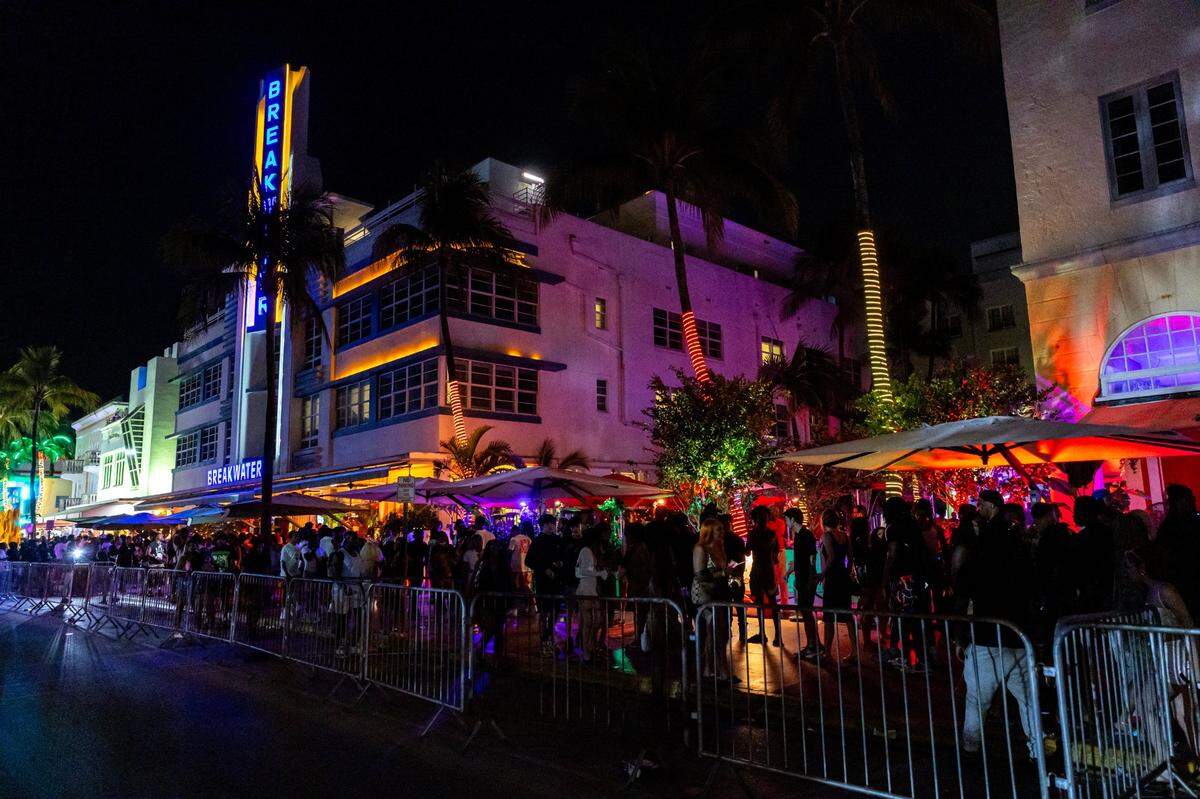 People walk along the sidewalk on Ocean Drive on Friday, March 15, 2024.