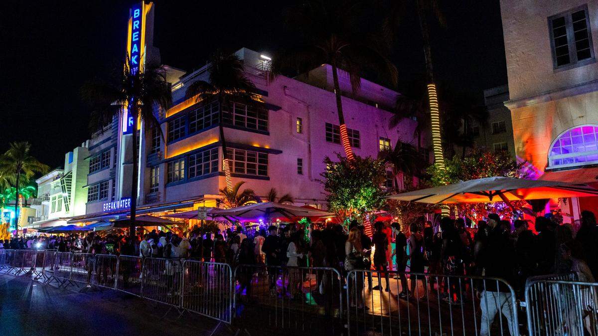 People walk along the sidewalk on Ocean Drive during spring break 2024 in Miami Beach on Mar. 15, 2024.