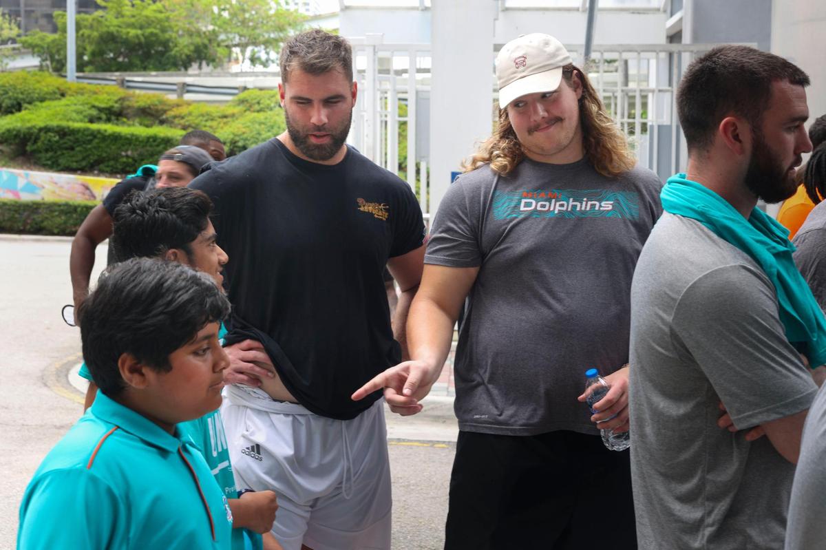 Blaise Andries, right, offensive lineman of the Miami Dolphins rookie class, and Kellen Diesch, another offensive lineman, talk with Zain Khan, 11, bottom left, and Bilan Siddiqui, 14, kids from the Islamic Center of Greater Miami, during a historic walking tour of Downtown Miami on Wednesday, June 15, 2022, beginning with tour leaders at the History Miami Museum. Andries is from Minnesota and Diesch is from Dallas.
