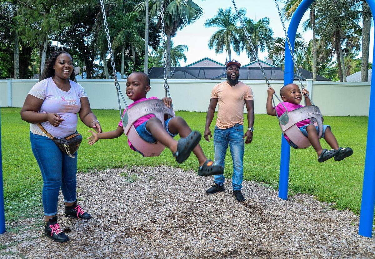 Jonise Louis y su esposo, Milien, juegan con sus hijos Brayden (izquierda), de 4 años, y Giovanni Louis, de 2, en un parque en Lauderhill, Florida, el sábado 7 de octubre de 2023. Es madre de dos hijos y padece cáncer de mama metastásico. Encontró apoyo de otras mujeres embarazadas con cáncer de mama.