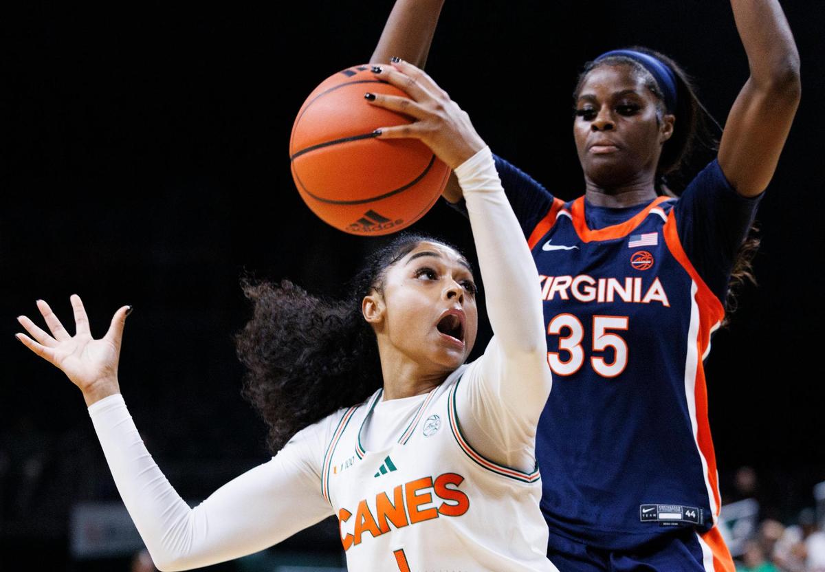 Miami Hurricanes Lemyah Hylton (1) looks to the hoop while guarded by Virginia Cavaliers Latasha Lattimore (35) during the second quarter of a game on Thursday, Jan. 30, 2025, at Watsco Center in Coral Gables, FlA.
