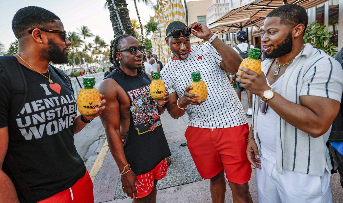 Left to right, holding their pineapple drinks are Sanjay Davis, Lee Fortner, Cedrick Thomas, and Darius Bowie, of Mississippi, along Ocean Drive, Miami Beach, Florida