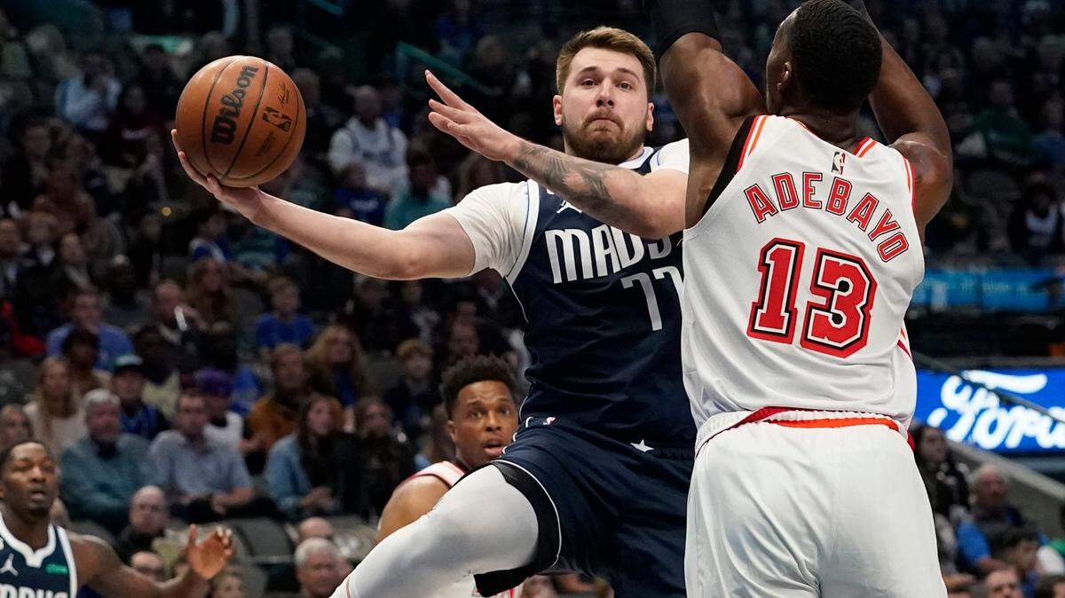 Dallas Mavericks guard Luka Doncic (77) is defended by Miami Heat center Bam Adebayo (13) during the first half of an NBA basketball game in Dallas, Friday, Jan. 20, 2023.