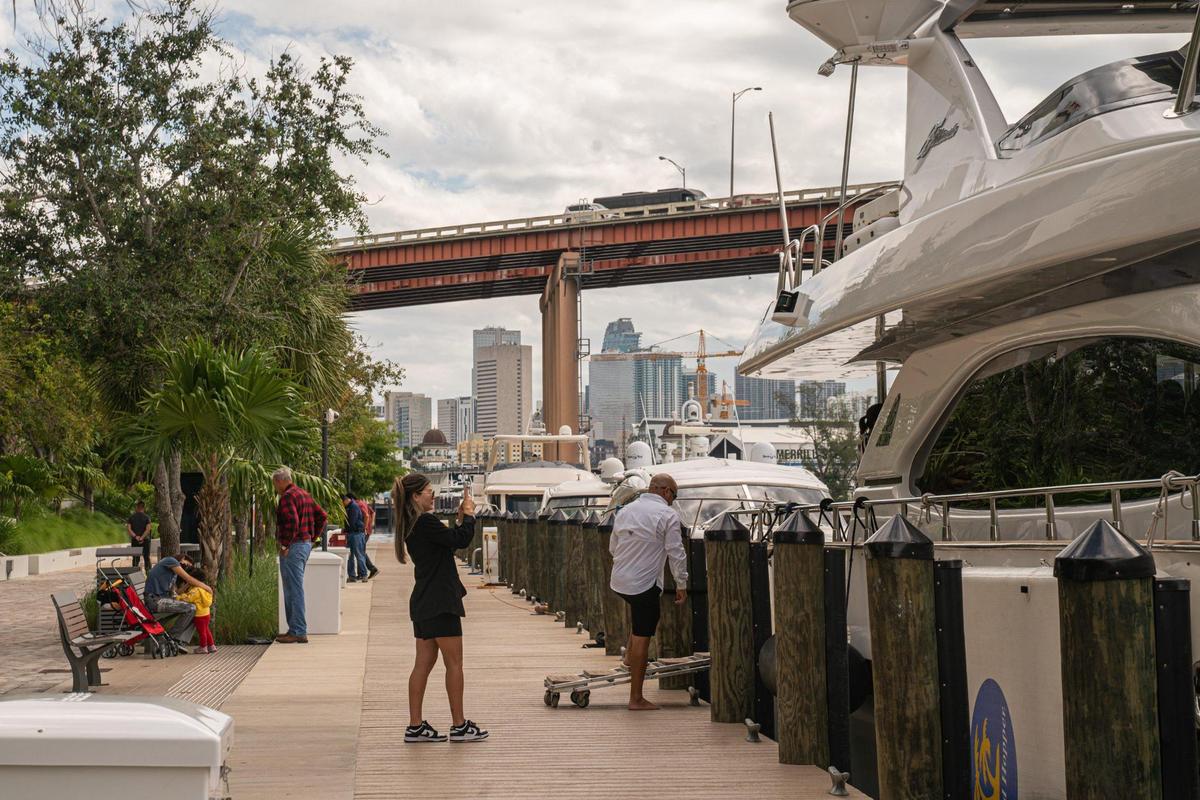 People can watch the boats go by on the Miami River, just outside River Landing shopping center in Miami.