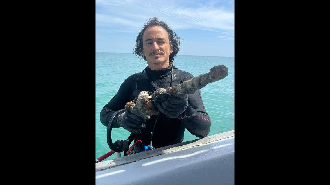 Diver Levin Shavers holds a rare flintlock found as a salvage team explored a shipwreck site linked to a Spanish treasure fleet that sank off Florida in a 1715 hurricane.