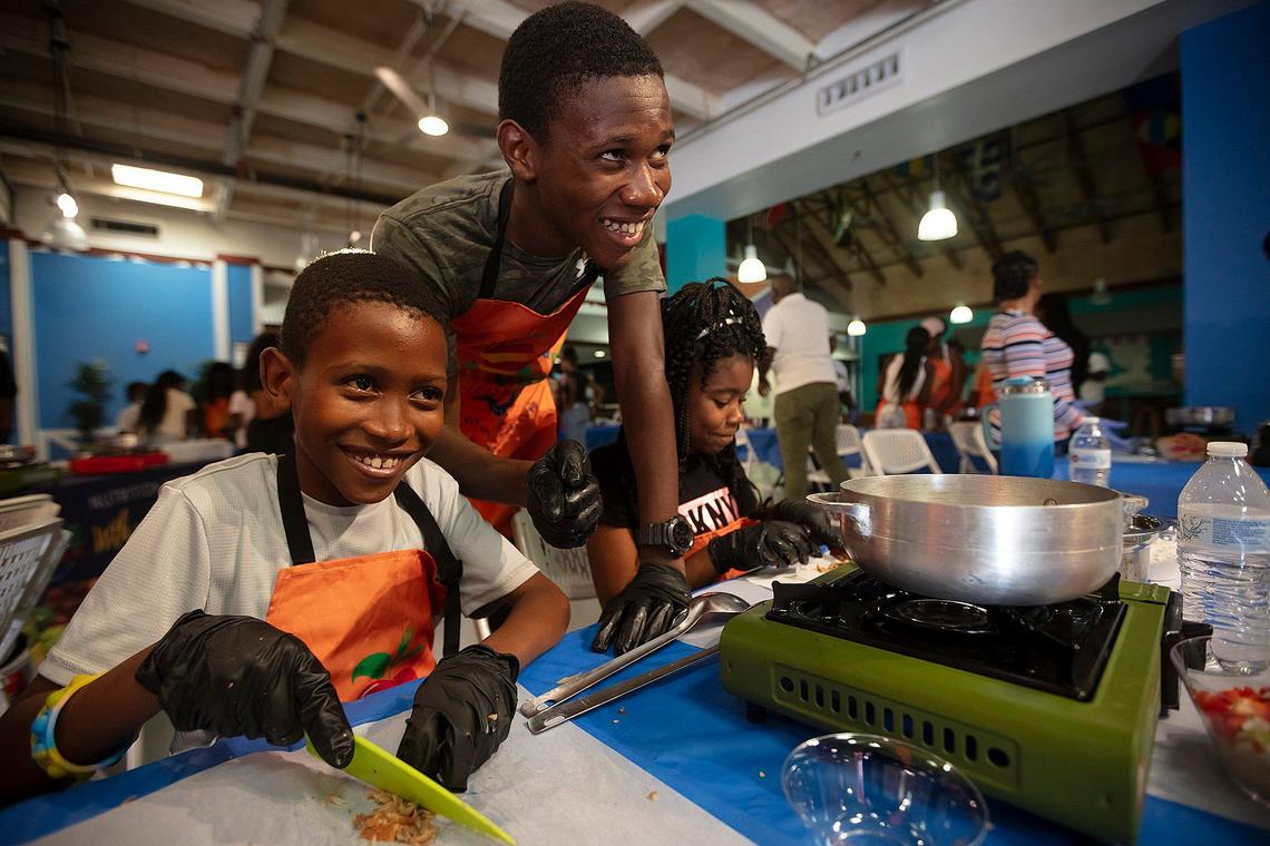 Renaldine Verdieu, 11, Timothy Louis, 15, and Giana Luigi Louis, 10, do prep work during the cooking class by Eatwell Exchange, the Miami nonprofit that teaches families how to prepare healthy meals from their homeland. They are at a class at the Little Haiti Cultural Complex.