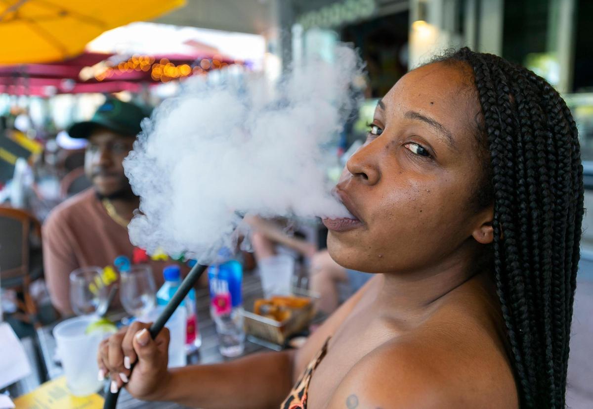 Jamonica Kelly, a tourist from Atlanta, smokes from a hookah while visiting Miami Beach on Friday, Feb. 25, 2022.