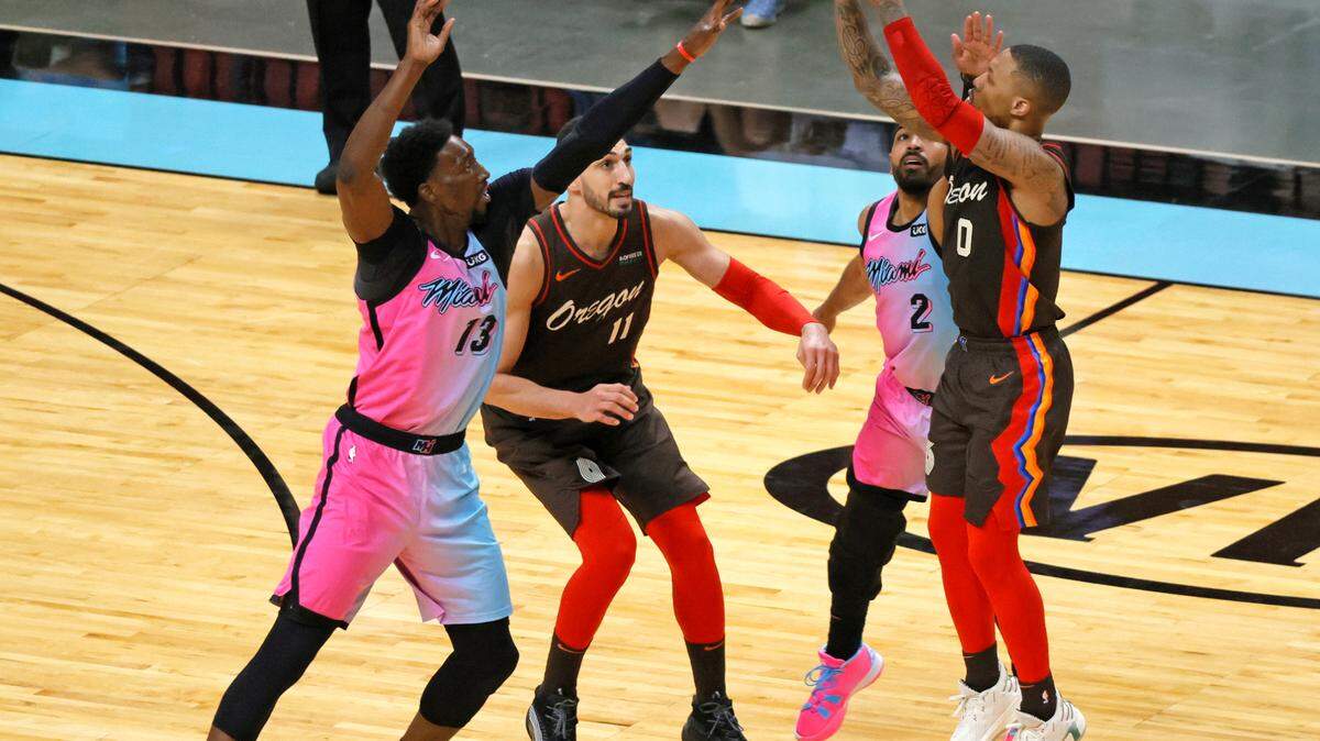 Portland Trail Blazers guard Damian Lillard (0) shoots over Miami Heat players Bam Adebayo (13) and Gabe Vincent (2) in the third quarter of their NBA basketball game at the AmericanAirlines Arena on Thursday, March 25, 2021.