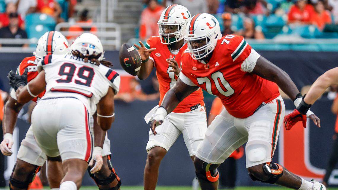 Miami Hurricanes offensive lineman Markel Bell (70) blocks Ball State Cardinals defenders as quarterback Cam Ward (1)takes a snap in the first half of an NCAA football game at Hard Rock Stadium in Miami Gardens, Florida on Saturday, September 14, 2024.