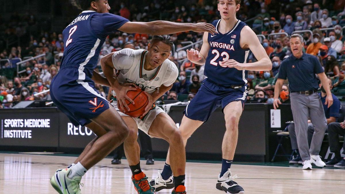 Miami Hurricanes guard Isaiah Wong (2) ducks under the arm of Virginia Cavaliers guard Reece Beekman (2) as he drives to the basket in the first half at the Watsco Center in Coral Gables on Saturday, February 19, 2022.