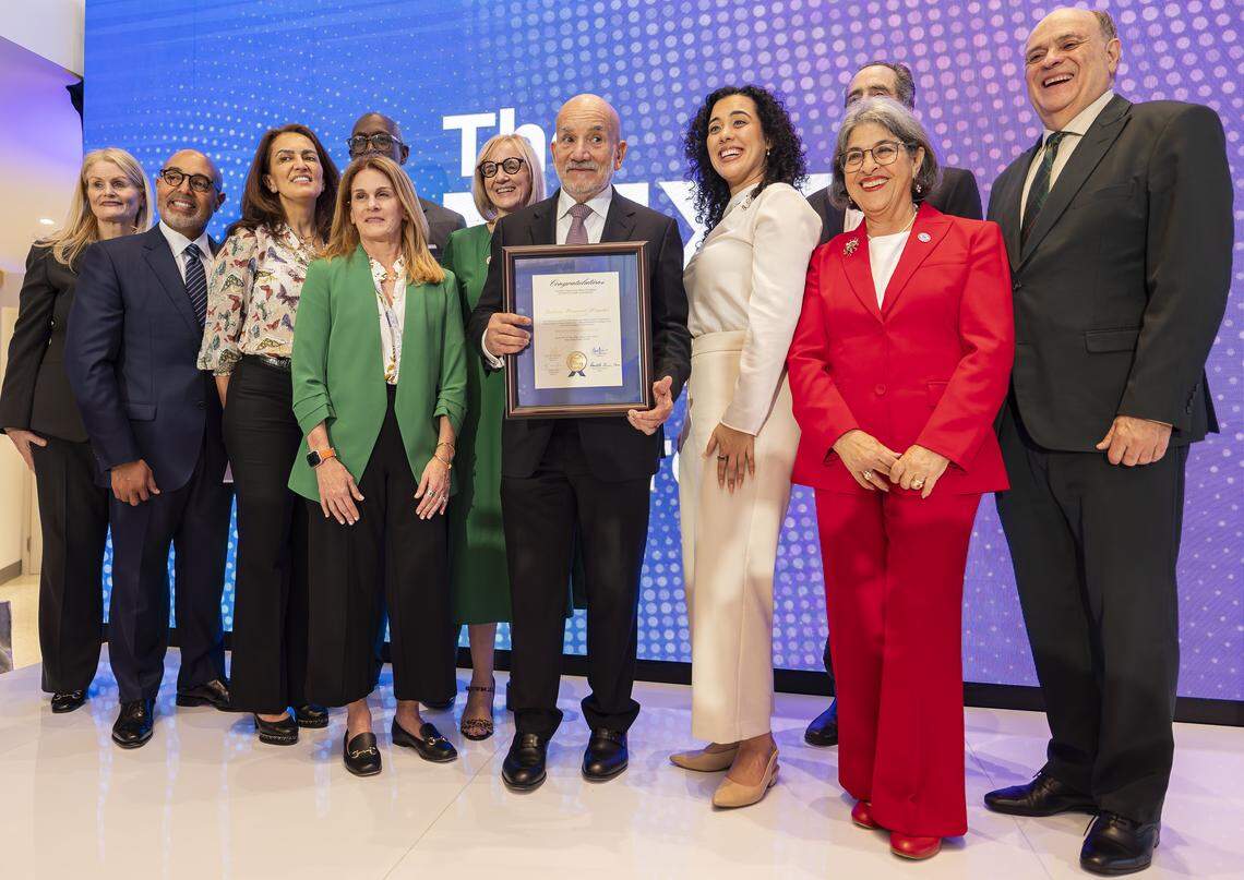 Miami-Dade County Mayor Daniella Levine Cava, right, presents outgoing Jackson Health System chief executive officer Carlos Migoya, center, a recognition during a preview event of a new emergency room at Jackson Memorial Hospital on Thursday, April 16, 2026, in Miami, Fla.