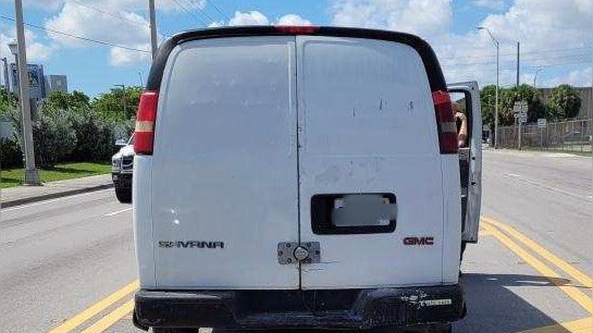 A white GMC van is parked on a street in Opa-locka Thursday, Aug. 18, 2022. Federal agents say the van was used to transport six Cuban migrants who had just been smuggled into the United States.