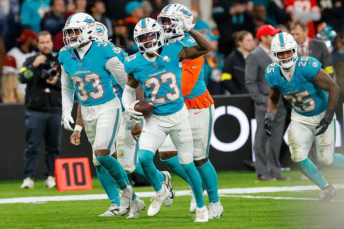 Miami Dolphins' cornerback #23 Jack Jones (C) celebrates intercepting a pass thrown by Washington Commanders' quarterback #08 Marcus Mariota  during overtime in the NFL match between Miami Dolphins and Washington Commanders at Santiago Bernabeu Stadium in Madrid on November 16, 2025. (Photo by Oscar DEL POZO / AFP) (Photo by OSCAR DEL POZO/AFP via Getty Images)          