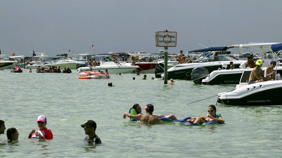 People enjoy the water at the Nixon Beach sandbar off Key Biscayne.