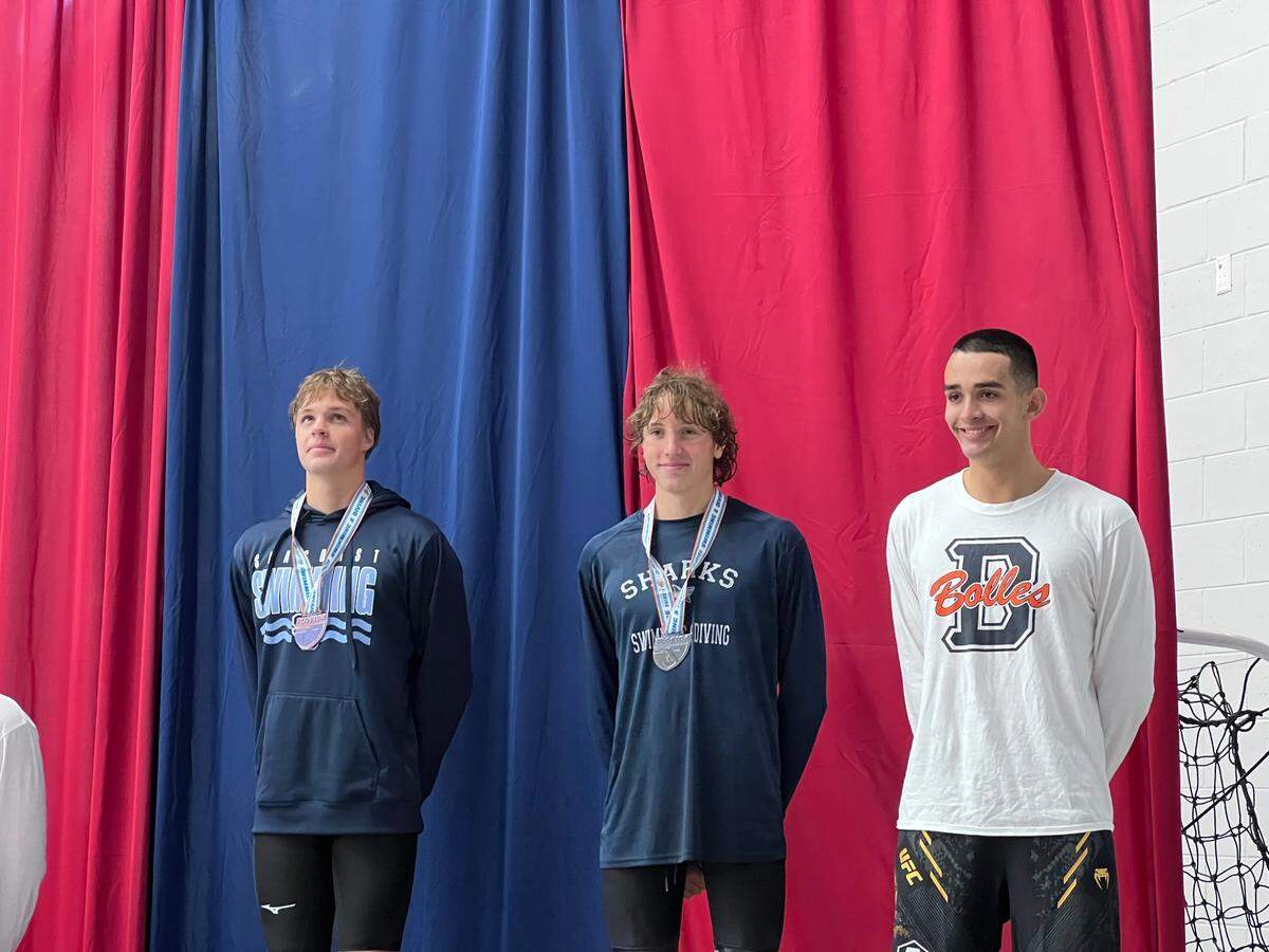 NSU University School’s Juan Vallmitjana (middle) receives his medal after earning second in the 500 freestyle at the Class 1A state championship meet in Ocala, Fla.