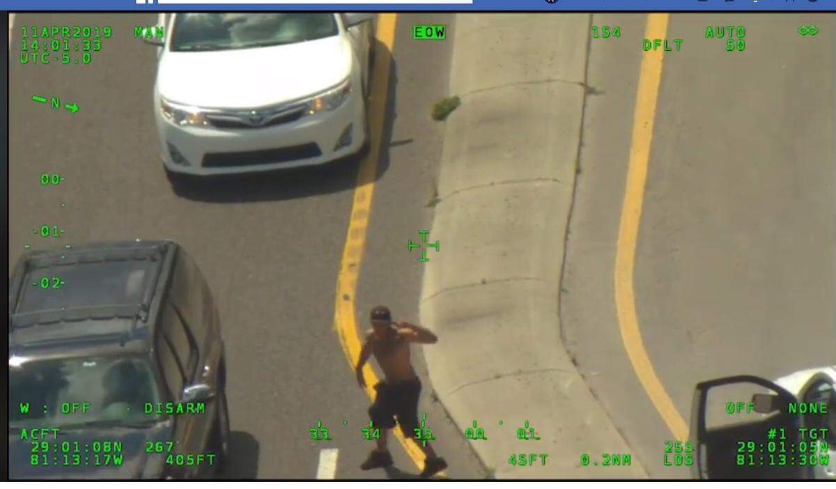 Volusia County Sheriff’s deputies say this is Phillip Thomas Marsh, 30, a Florida man who carjacked a woman in Deltona, led deputies on a chase and shootout and, seen here, exited a white pickup truck with a gun to his head after officers stopped the car by blowing out its four tires.