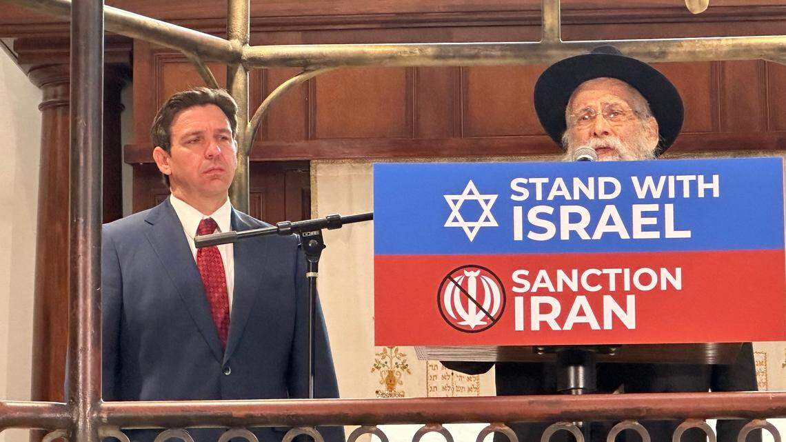 Florida Gov. Ron DeSantis stands by at the Shul of Bal Harbour on Oct. 10, 2023 as Rabbi Sholom D. Lipskar speaks about the terror attack on Israel three days earlier by Hamas fighters.