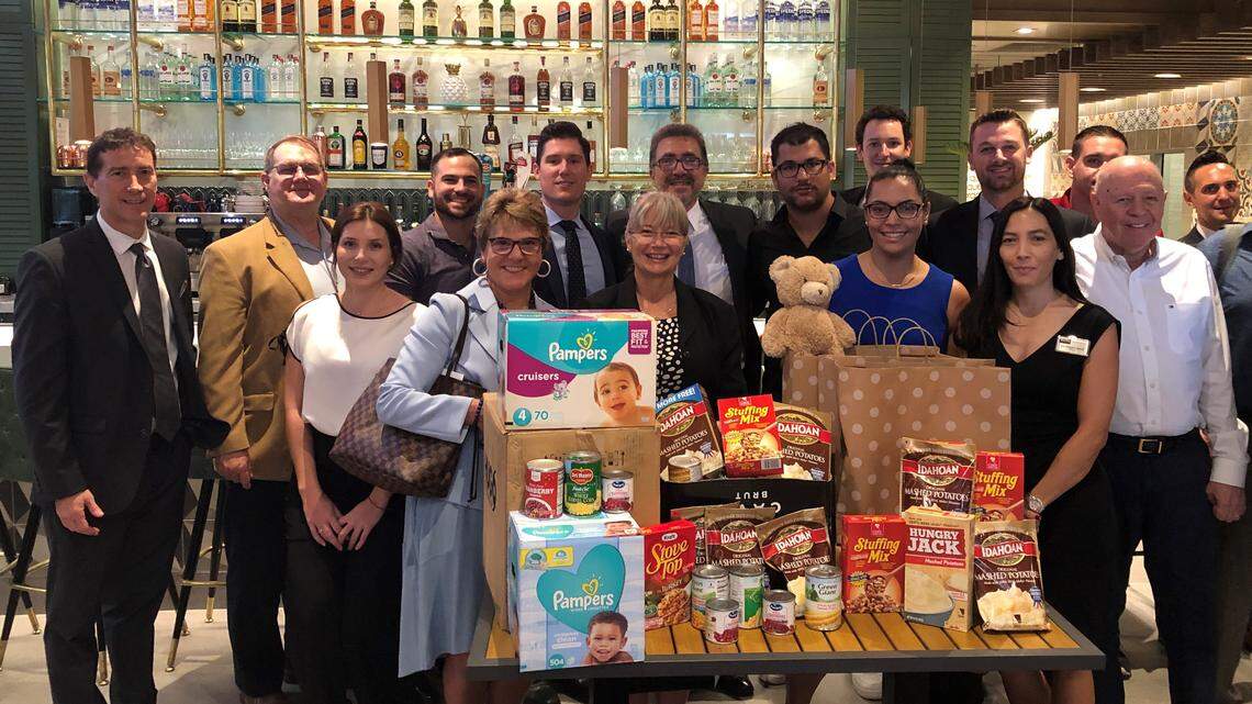 Members of the networking group Prime Time Miami (Brickell) Chapter gather with some of the donations they’ve collected for lesser-known charities in South Florida.