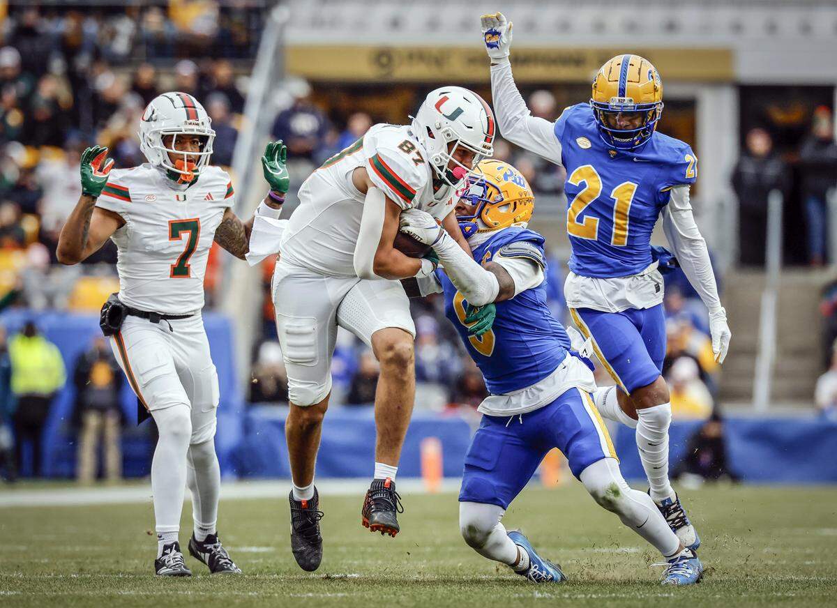 Miami Hurricanes tight end Alex Bauman (87) on a first down pass reception as Pittsburgh Panthers linebacker Kyle Louis (9) defends during the first half of an NCAA football game at Acrisure Stadium in Pittsburgh, PA, on Saturday, November 29, 2025.