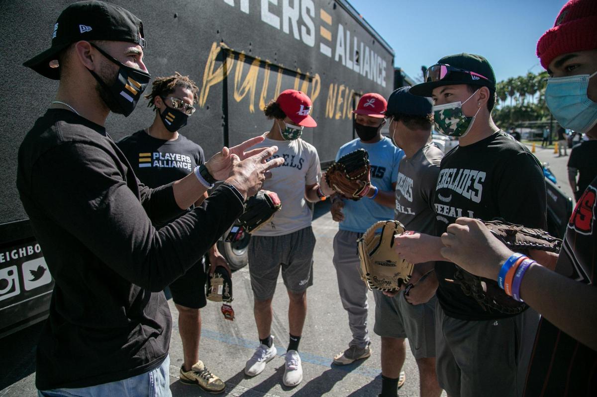 Miami, Florida, January 5, 2021- Major Leaguers Deven Marrero (left) and Jon Jay (second from left), talk to members of the Everglades High School Baseball team at Gibson Park in Overtown during a visit by the Players Alliance while on their Pull Up Neighbor Tour. On December 1, 2020, The Players Alliance Launched a two month, cross-country mobile tour in partnership with Pull Up Neighbor, a Black-owned community response team. Many underserved children have endured countless losses due to the pandemic, including access to learn and play baseball. This programÕs goal is to help counter all that and provide support during these uncertain times. The Players Alliance, a nonprofit organization comprised of more than 150 active and former Major League Baseball players, was at Overtown’s Gibson Park from 1 p.m.-3 p.m. on Tuesday, January 5, 2021, as part of its Pull Up Neighbor tour. The group, led by one-time Marlin Curtis Granderson, has already stopped at 15 other cities throughout the country.