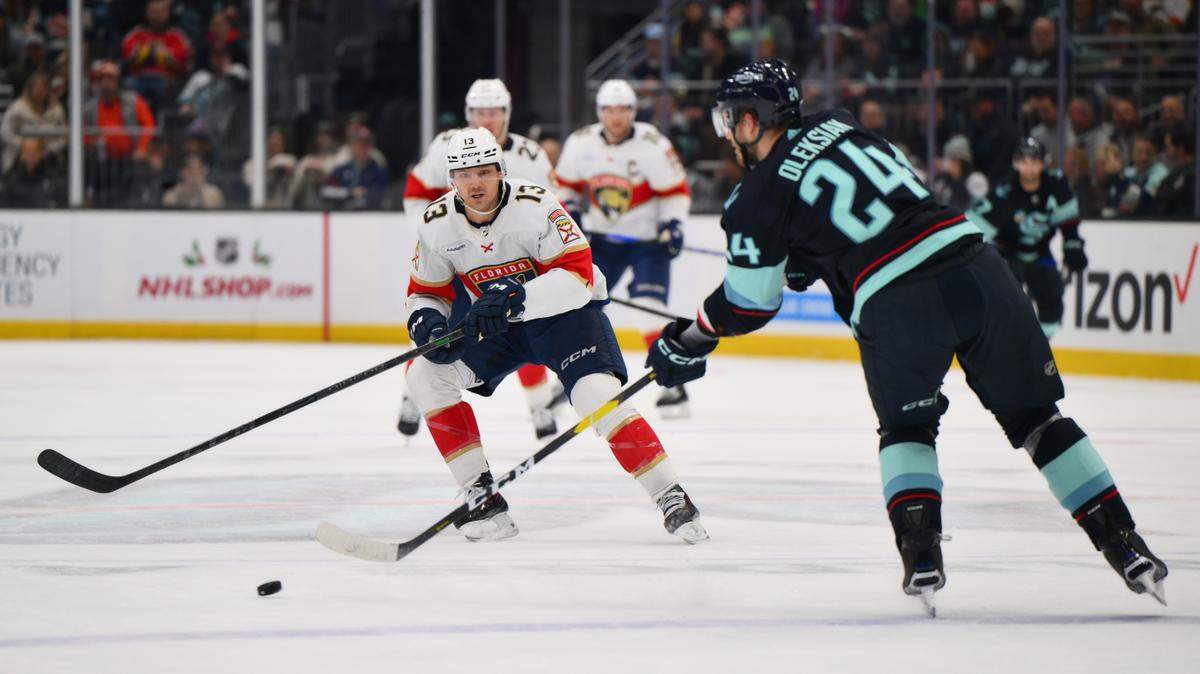 Dec 12, 2023; Seattle, Washington, USA; Florida Panthers center Sam Reinhart (13) defends Seattle Kraken defenseman Jamie Oleksiak (24) during the first period at Climate Pledge Arena. Mandatory Credit: Steven Bisig-USA TODAY Sports.
