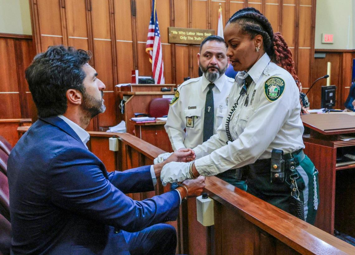 Ohad Fisherman, a friend of rape and sex trafficking suspects Oren and Alon Alexander, is handcuffed by corrections officer in court Wednesday. Fisherman turned himself in on a single charge of sex assault from an incident on Miami Beach about a decade ago.
