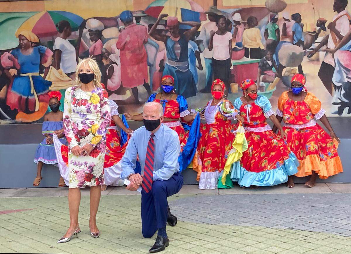 Joe Biden kneels for a socially-distanced photo in Little Haiti.