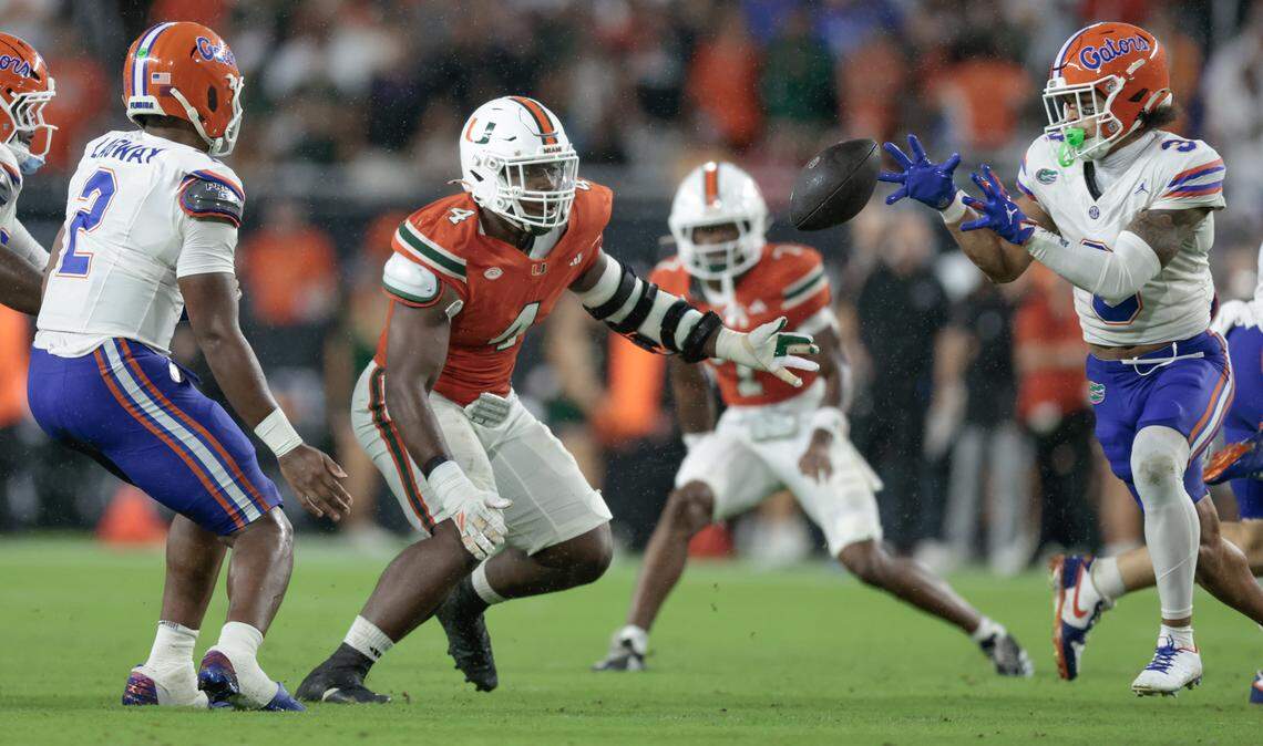 Florida Gators quarterback DJ Lagway (2) pitches the ball to wide receiver Eugene Wilson III (3) as Miami Hurricanes defensive lineman Rueben Bain Jr. (4) defends in the first half of their NCAA football game at Hard Rock Stadium in Miami Gardens, Florida, on Saturday, September 20, 2025.