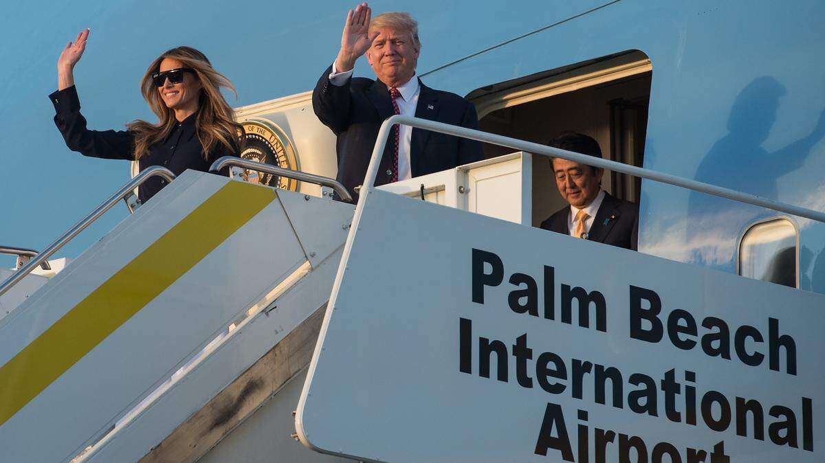 President Donald Trump, First Lady Melania Trump and then-Japanese Prime Minister Shinzo Abe walk off Air Force One at Palm Beach International Airport in Florida as they arrived to spend the weekend at Trump's Mar-a-Lago resort on Feb. 10, 2017. 