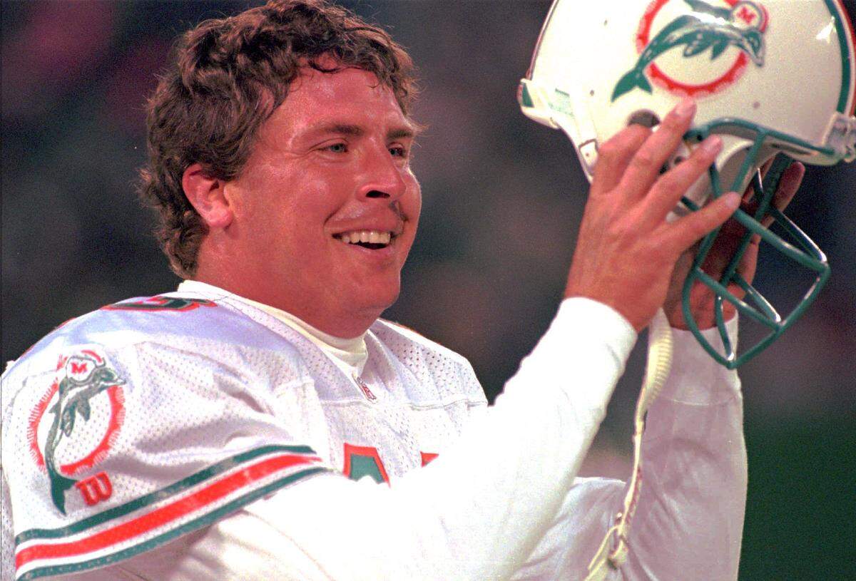 FILE--Miami Dolphins quarterback Dan Marino removes his helmet after throwing the winning touchdown against the New York Jets during the fourth quarter Sunday afternoon, Nov. 27, 1994, at Giants Stadium in East Rutherford, N.J. Marino downplays his matchup with Joe Montana but acknowledges that he running out of chances to win a Super Bowl ring. The Dolphins face the Kansas CIty Chiefs Saturday, Dec. 31, 1994, in the playoffs. (AP Photo/Eric Miller)