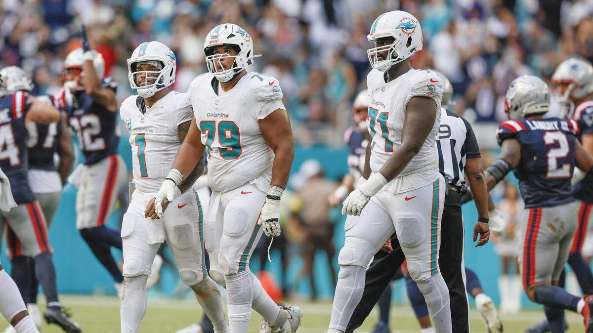 Miami Dolphins quarterback Tua Tagovailoa (1) offensive tackle Larry Borom (79), and offensive tackle Kion Smith (71) walk off the field in the final moments of the game against the New England Patriots during their NFL football game at Hard Rock Stadium in Miami Gardens, Florida, on Sunday, September 14, 2025. 