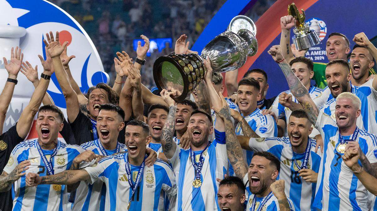 Argentina forward Lionel Messi (10) holds the trophy with his teammates after defeating Colombia in their Copa America 2024 Final soccer match at Hard Rock Stadium on Sunday, July 14, 2024, in Miami Gardens, Fla.