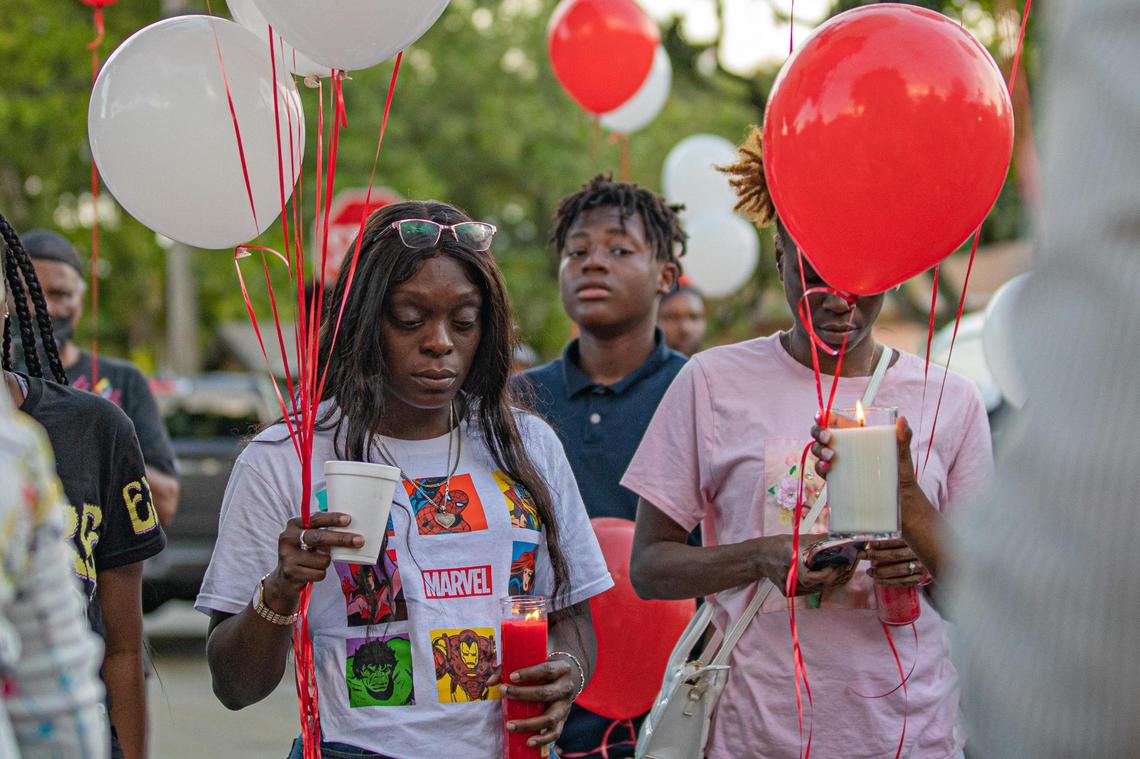 People hold candles and balloons during a vigil on Tues., Sept. 13, 2022 for Elizabeth Level, who passed away after caught in the crossfire of a shooting last Friday night in front of her house in Miami, Fla.