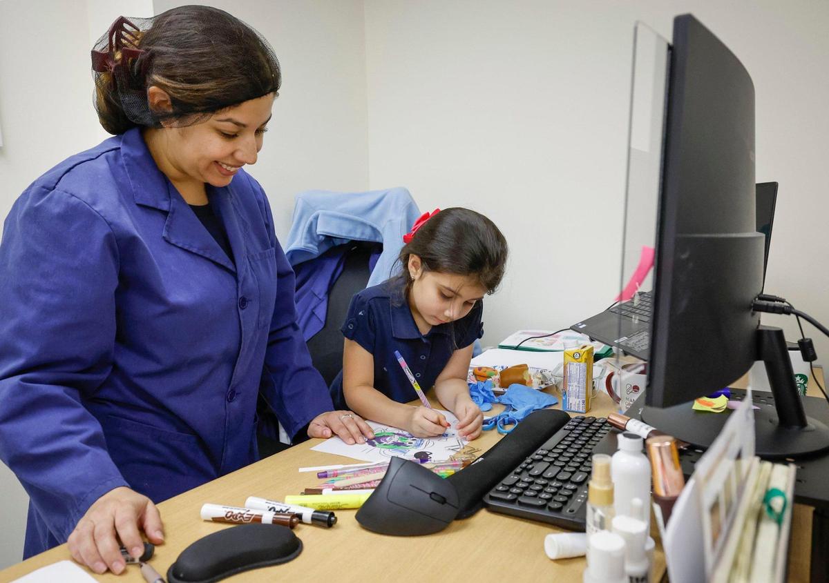 Madelaine Escobar Duran, head cosmetic chemist at Concept II, spends time with her daughter Emily Valdez, 5, during a break from work in Doral, Florida, on Thursday, Oct. 24, 2024.