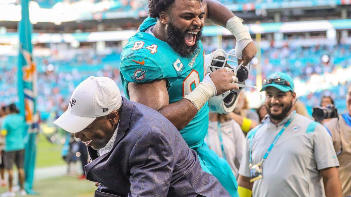 Miami Dolphins defensive tackle Christian Wilkins (94) celebrates with general manager Chris Grier after defeating the New York Jets at Hard Rock Stadium in Miami Gardens on Sunday, January 8, 2023.
