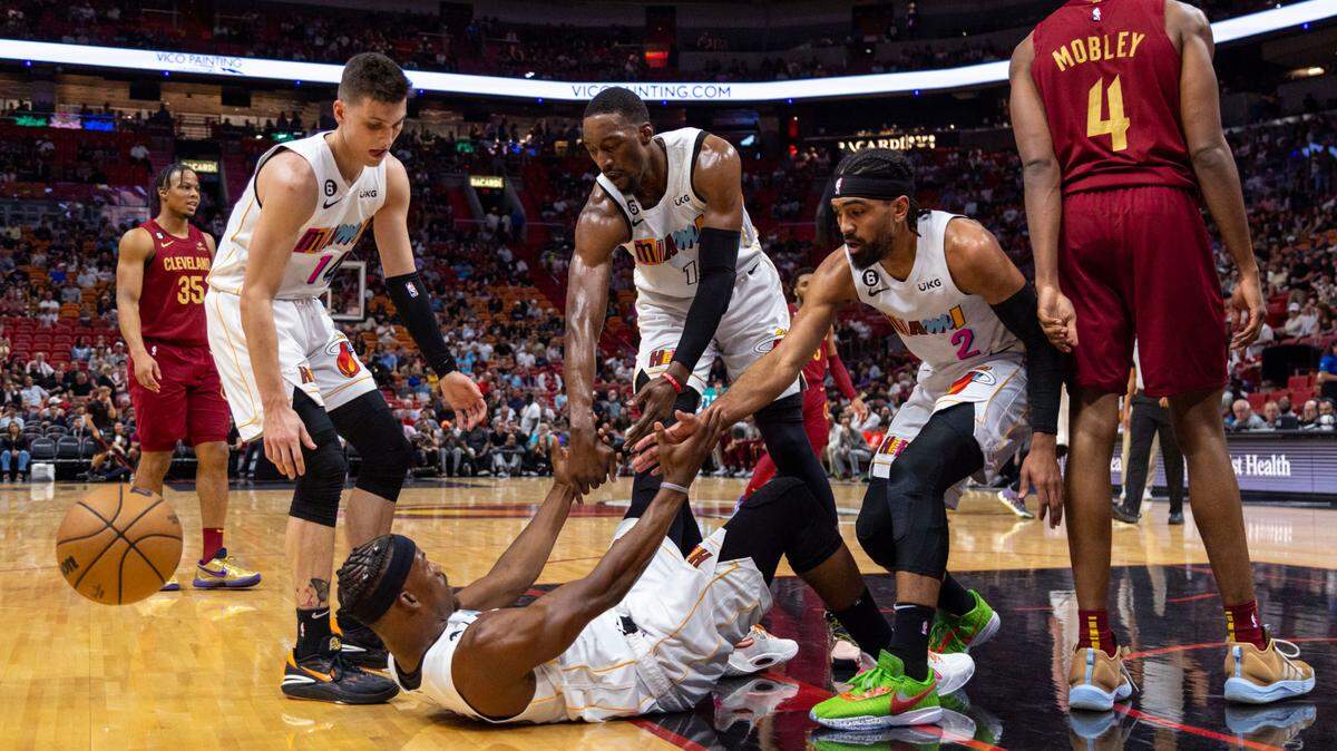 Miami Heat teammates Gabe VIncent (2), Tyler Herro (14) and Bam Adebayo (13) help pick up Jimmy Butler (22) off the floor during the first half of an NBA game against the Cleveland Cavaliers at Miami-Dade Arena in Miami on March 8, 2023.