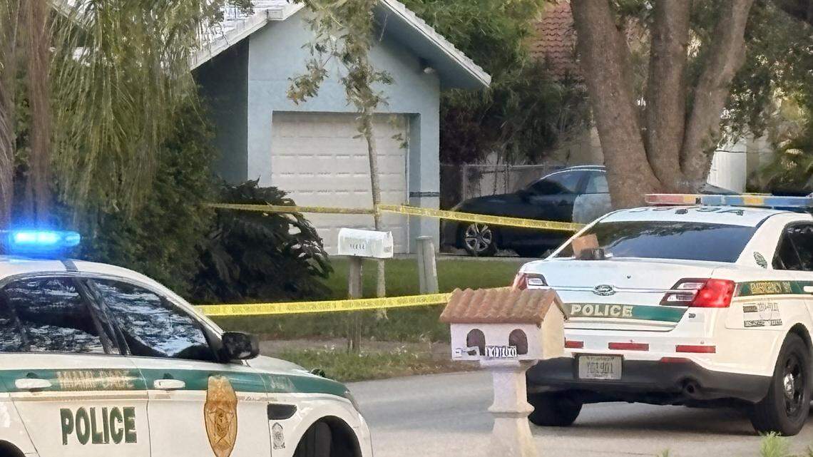 Miami-Dade Sheriff’s Office patrol cars are parked in front of a Palmetto Bay home on Wednesday, April 22, 2026. Detectives say a man shot and killed his adult son inside the house.