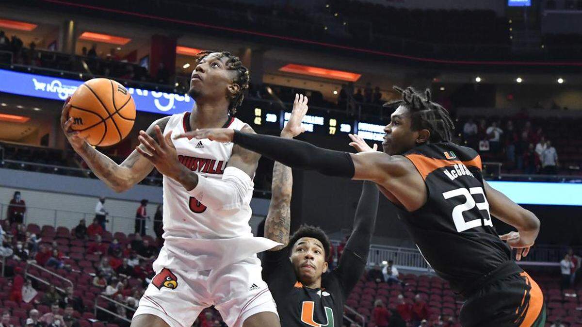 Miami’s Kameron McGusty (right) defends Louisville’s El Ellis during the Hurricanes’ 70-63 victory over the Cardinals at the KFC Yum! Center on Feb. 16, 2022.