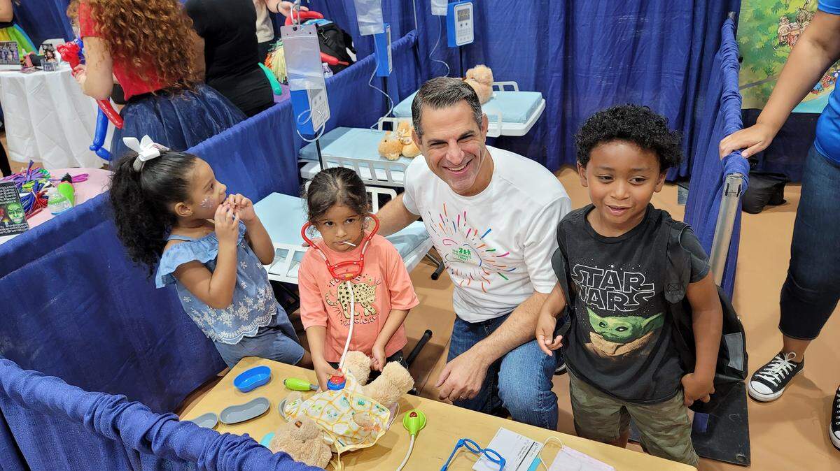 Children’s Trust president James R. Haj poses with kids at the 2023 Family Expo at Miami-Dade College.