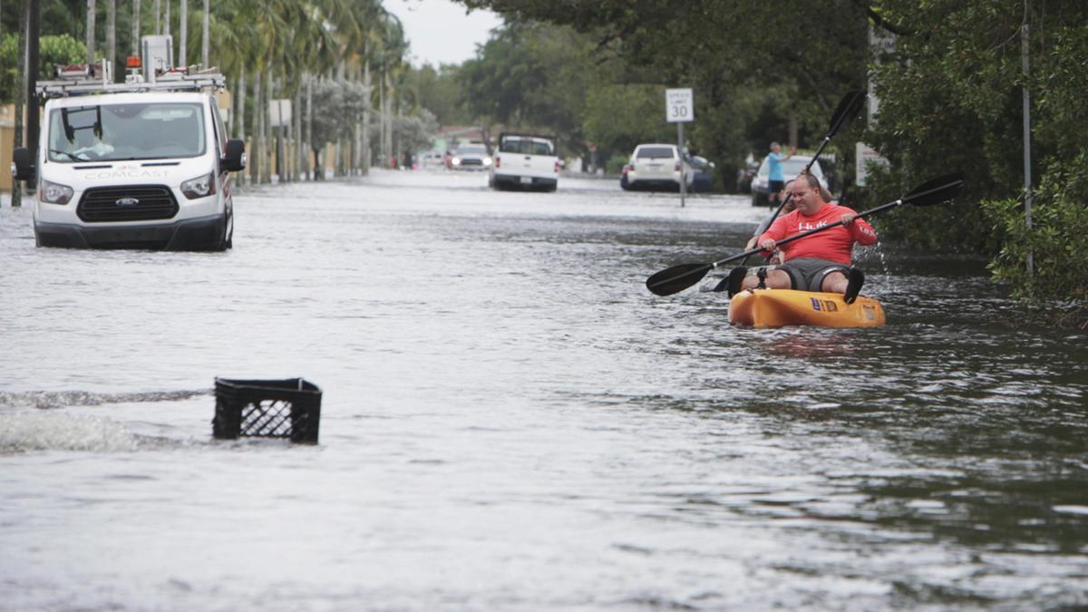 Residents make their way through the high water on Northwest 52nd Avenue in Miami Gardens on Monday, Nov. 9, 2020.