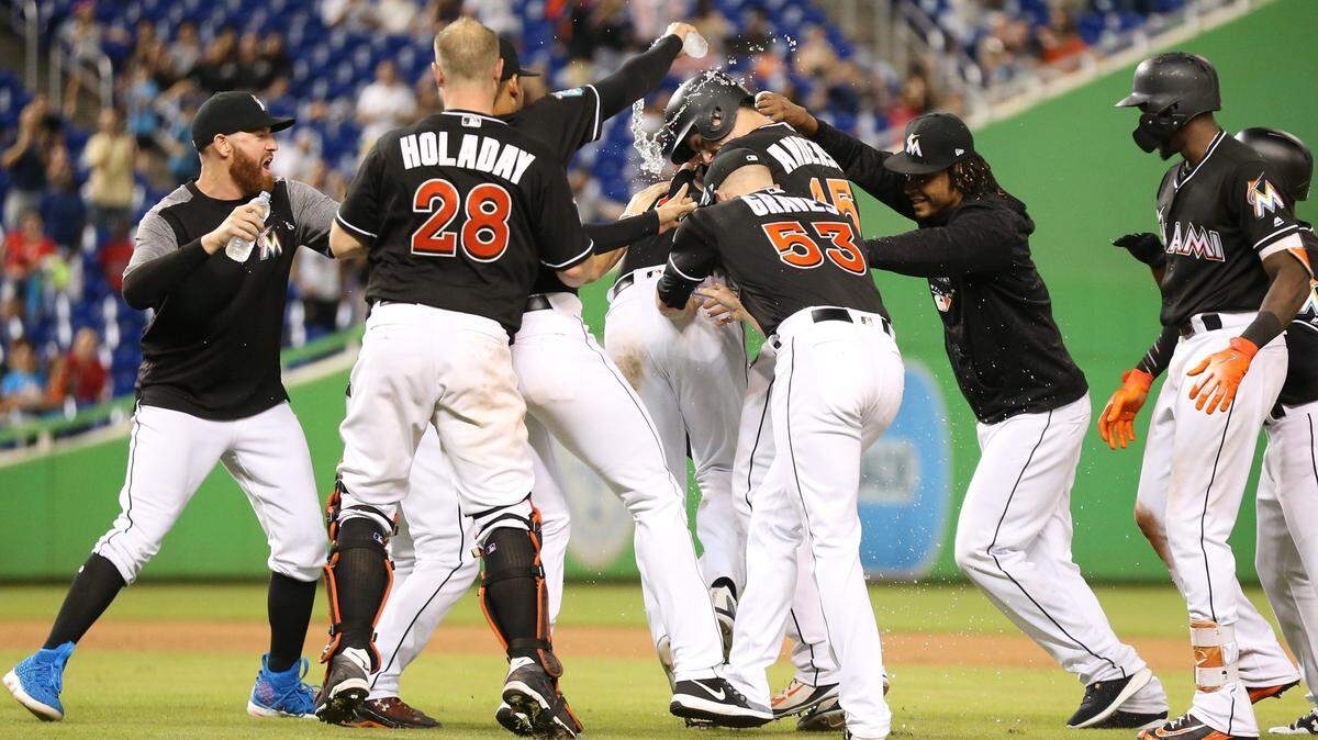 The Marlins celebrate on the field after Magneuris Sierra (34) scores the winning run on a single by J.T. Realmuto (11) in the tenth inning as the Miami Marlins host the Washington Nationals at Marlins Park on Saturday, July 28, 2018.