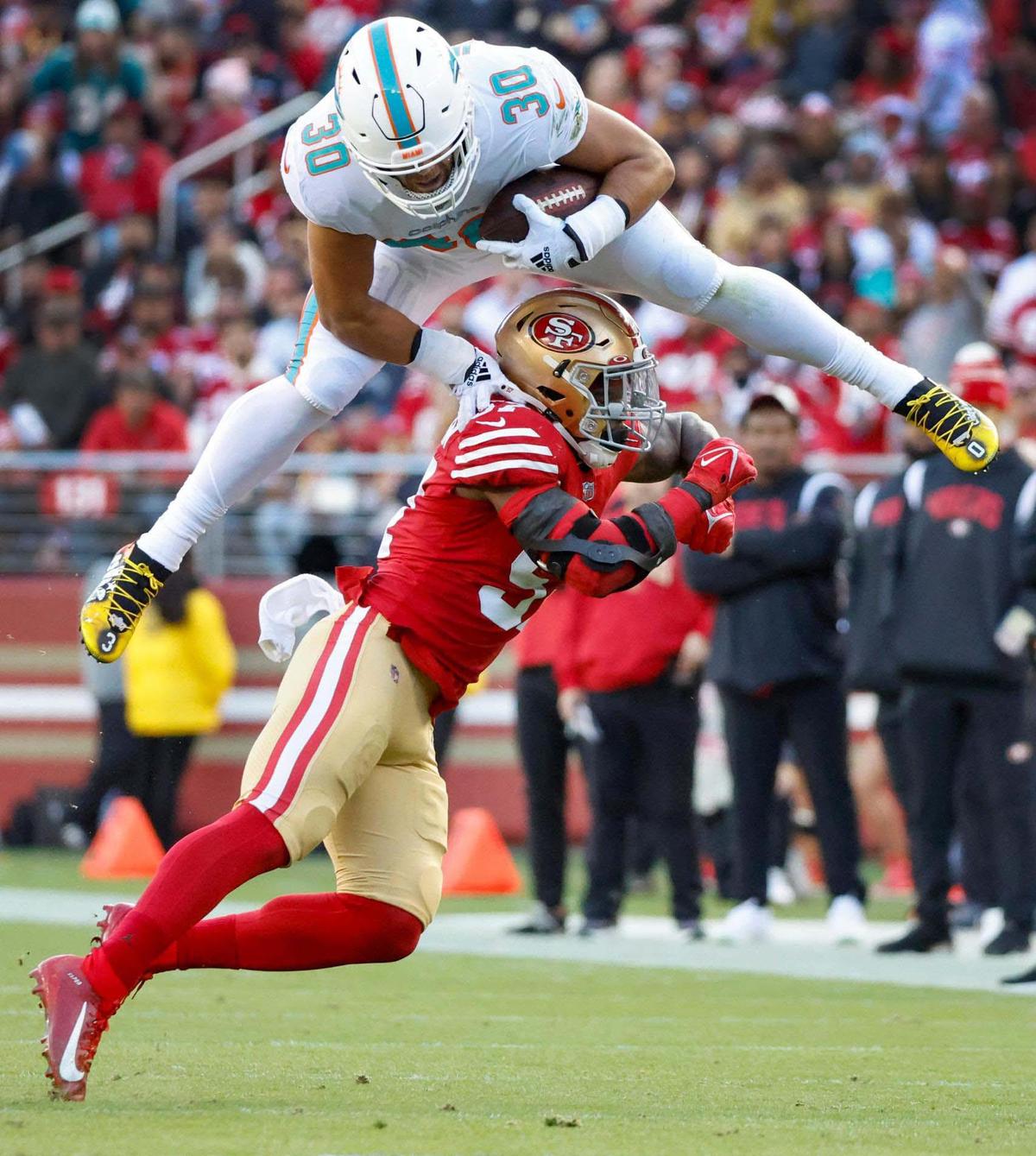 Miami Dolphins fullback Alec Ingold (30) hurdles over San Francisco 49ers linebacker Dre Greenlaw (57) in the second quarter for a first down at Levi’s Stadium in Santa Clara, California on Sunday, December 4, 2022.