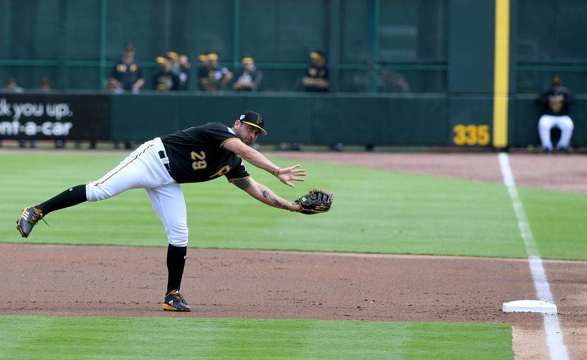 Francisco Cervelli practices his reach at first during the Pirates-Red Sox game at LECOM Park on Monday.